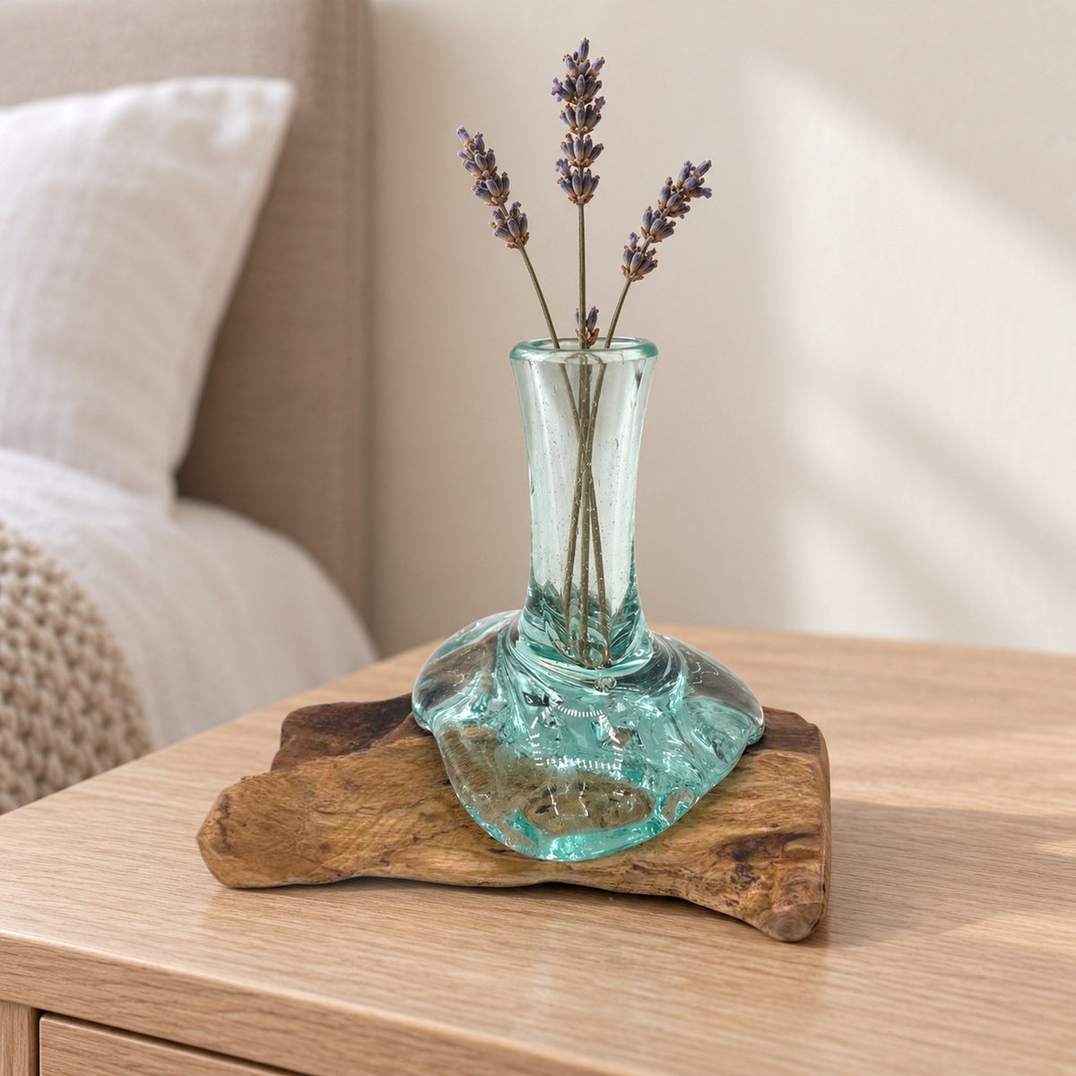 Small molten glass flower vase on wood with dried lavender, on a bedside table