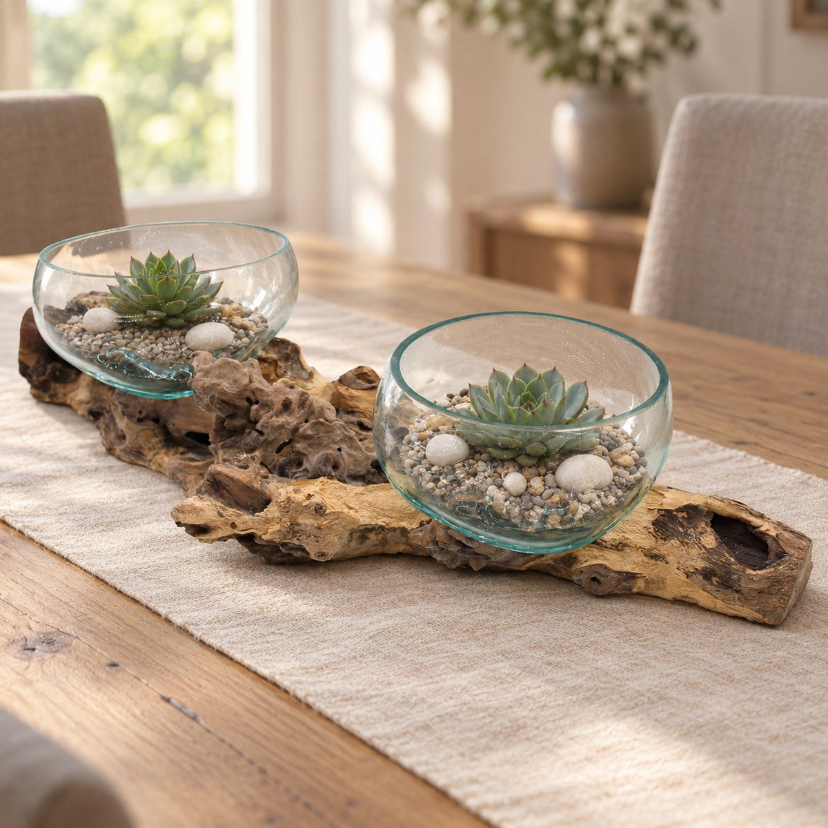 Extra large molten glass double piece on gamal wood, both bowls planted with succulents on gravel, along a linen runner on an oak dining table