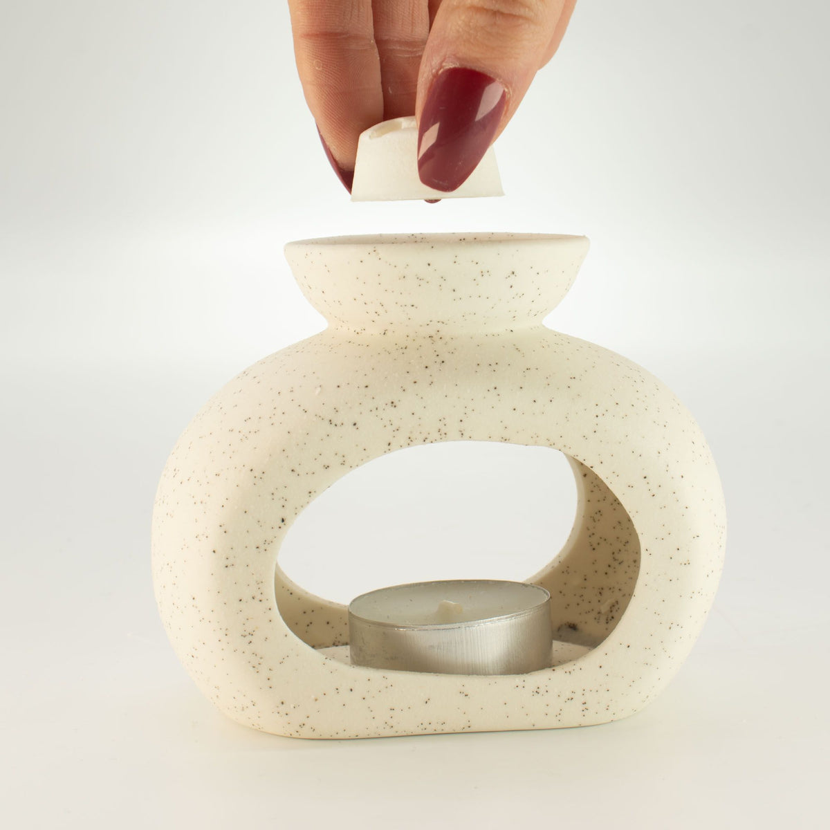 Placing a wax melt cube in the dish of the pebble wax burner
