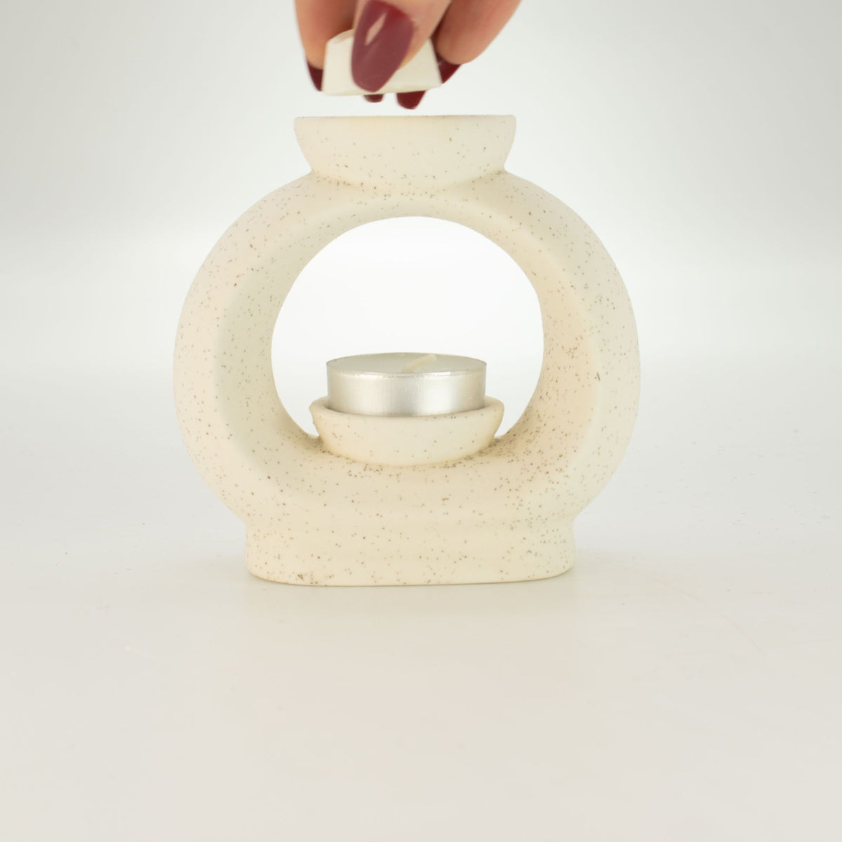 Placing a wax melt cube in the dish of the large pebble wax burner