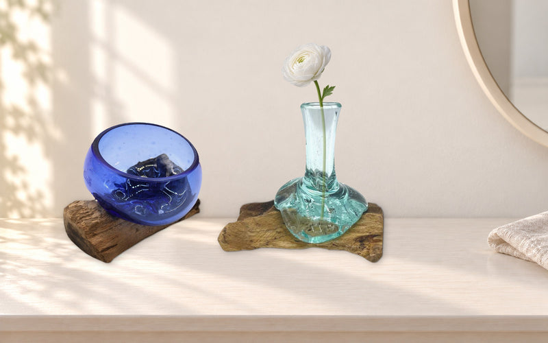 Mini cobalt blue molten glass bowl and small flower vase with a white ranunculus, on a painted dressing table beside a round mirror
