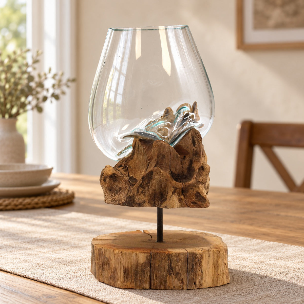 Large molten glass bowl on a wooden stand on an oak dining table