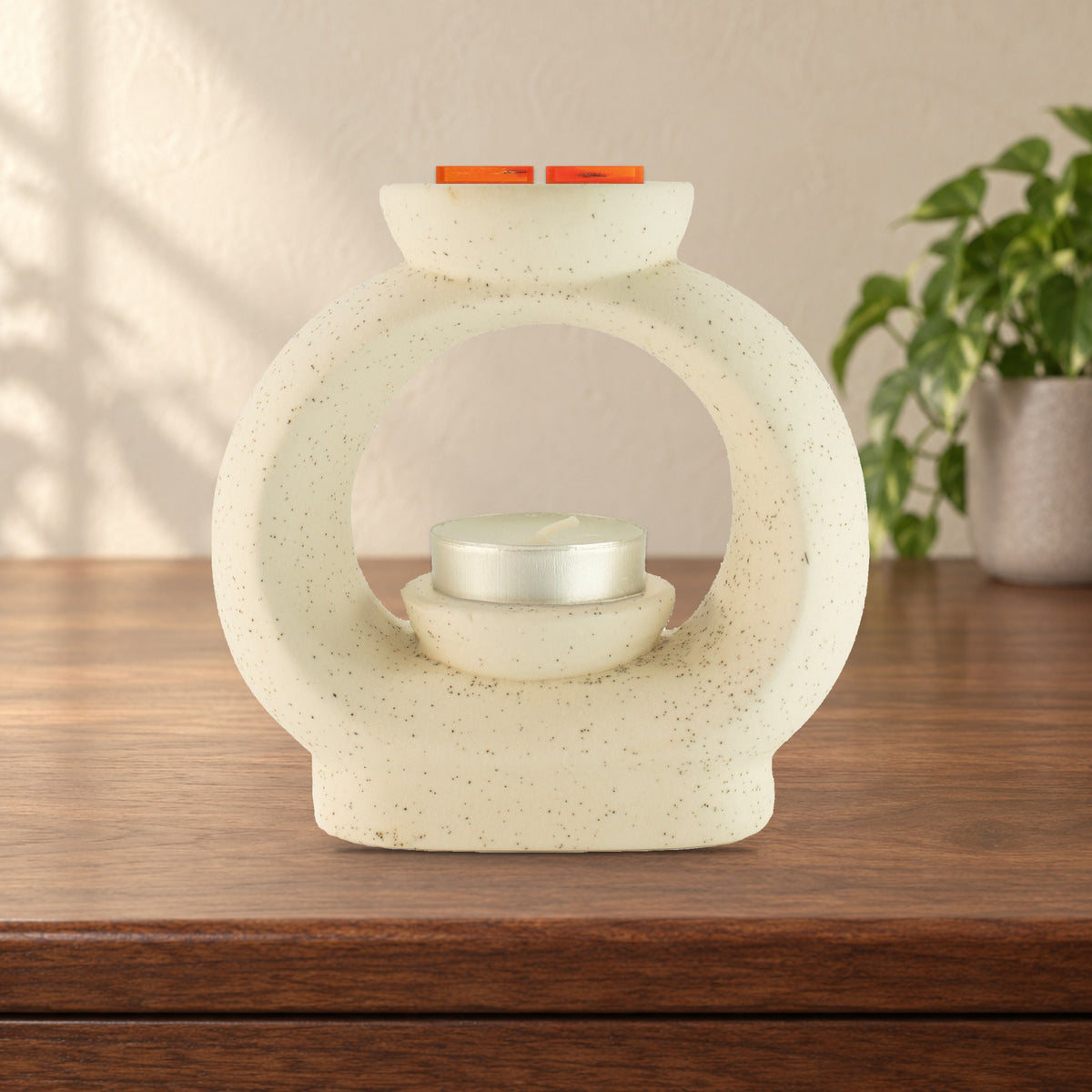 Large speckled off-white pebble wax burner with Carnelian Fire wax melt squares and an unlit tealight, on a walnut sideboard